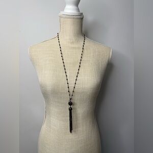 Long Petite black beaded necklace with dark chain tassels.